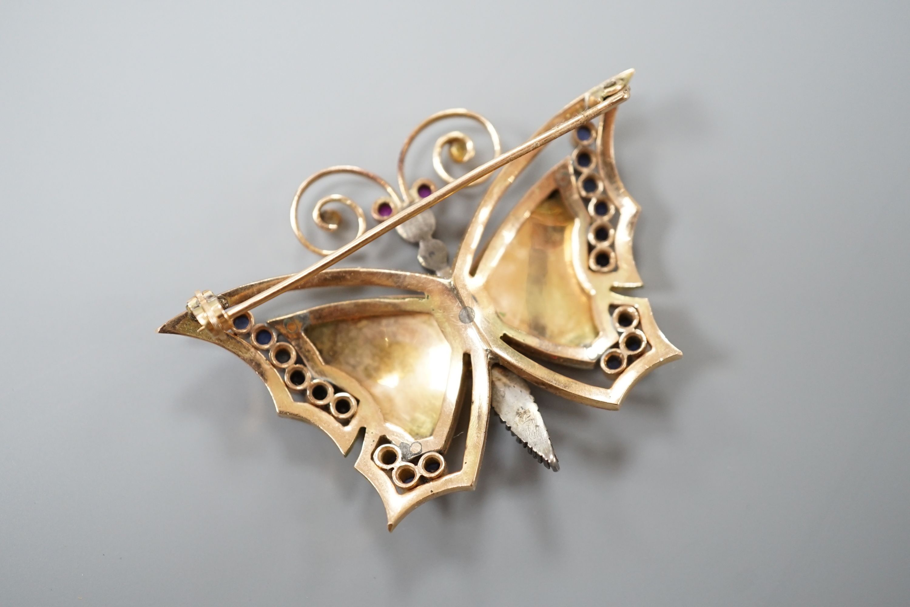 A continental yellow metal, polychrome enamel, rose cut diamond and gem set butterfly brooch (a.f.), width 50mm, gross weight 13.8 grams.